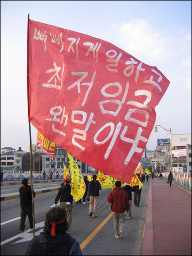 비정규직 노동자의 현실을 담은 깃발..."뼈빠지게 일하고 최저임금 왠말이냐" 